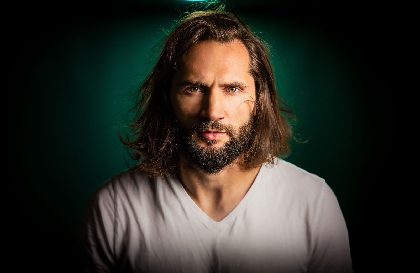 Nick Caraman, studio portrait against a dark green background